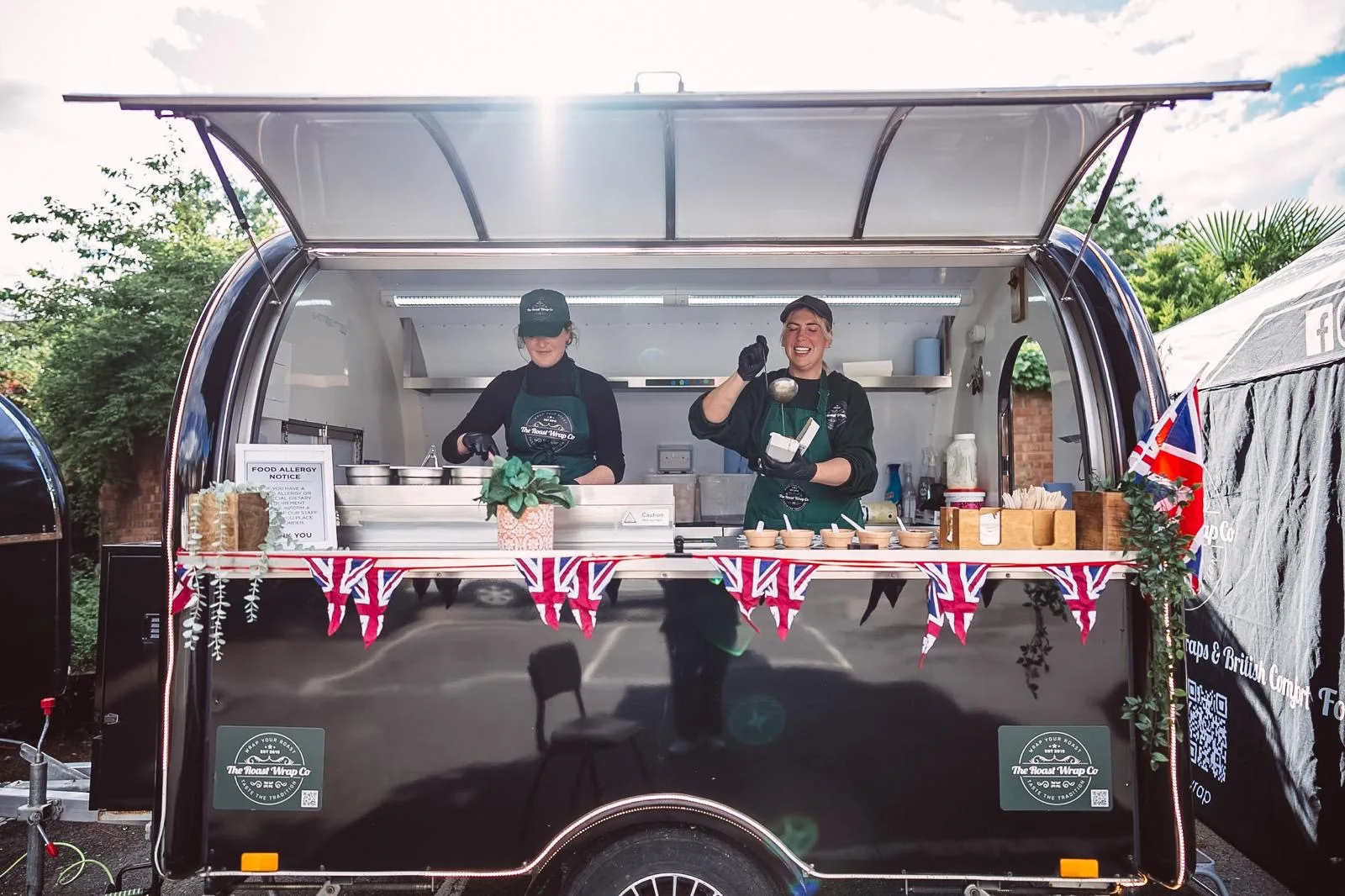 Two chefs serving from The Roast Wrap Co. trailer